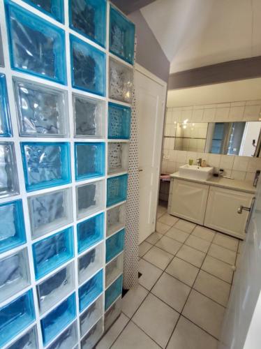 une cuisine avec des panneaux de verre bleu sur un mur dans l'établissement Gite des Ecureuils, vue mer, piscine privée, parking, climatisation, à La Ciotat