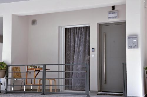 a balcony with a door and a table and chairs at In&Out in Nafplio