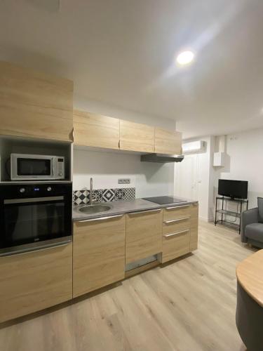 une cuisine avec une cuisinière et un micro-ondes dans l'établissement Entre terre et Mer, à Saint-Lormel