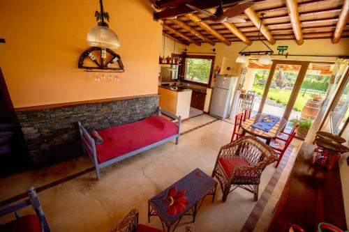 a living room with a red couch and a kitchen at Casa Santa Teresita in Cafayate