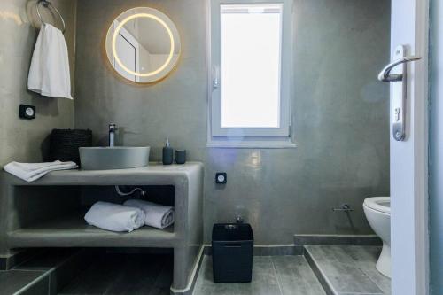 a bathroom with a sink and a toilet and a mirror at Ageri Suite in Vóthon
