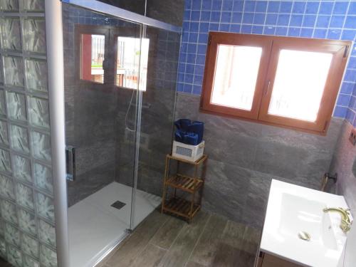 a bathroom with a shower with a glass door at Casa Rural El Pescador 