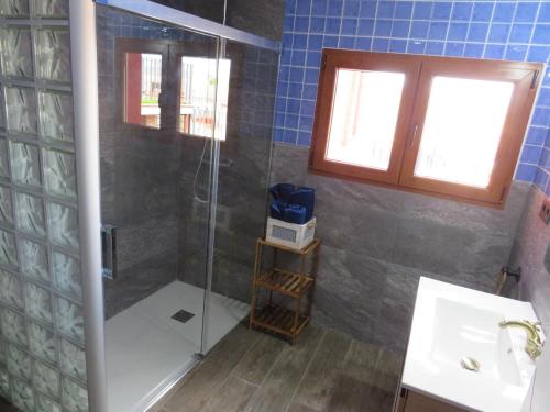 une salle de bain avec une douche avec une porte vitrée dans l'établissement Casa Rural El Pescador, à Mezalocha