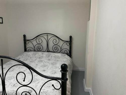 a bedroom with a black bed with a white comforter at Comfy Double Room In Our Shared House in Palmers Green