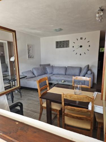 a living room with a couch and a table and a clock at Apartment MMP in Kotor