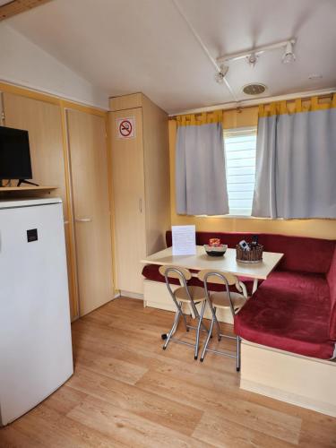 a small kitchen with a table and a refrigerator at A casinha da aguieira na Lands Hause L6 in Burinhosa