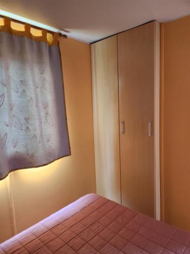 a bedroom with a bed with a curtain and a closet at A casinha da aguieira na Lands Hause L6 in Burinhosa