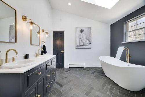 a bathroom with a large tub and a sink and a tub at Luxe Lrg Pocono House for 18 Hot Tub/Gameroom/Pool in Kunkletown