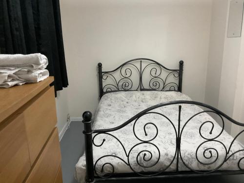 a black bed in a room with a dresser at Comfy Double Room In Our Shared House in Palmers Green