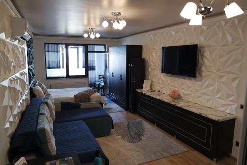 Habitación con cama, TV y sofá. en Apartment ǨS Brasov, en Brasov