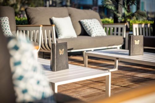 a living room with three tables and a couch at M Social Auckland in Auckland