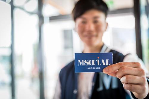 a man holding up a niscatal agent sign at M Social Auckland in Auckland