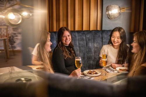 a group of women sitting around a table in a restaurant at M Social Auckland in Auckland