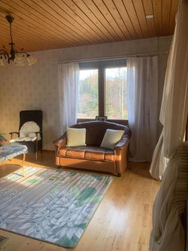 a living room with a couch and a large window at Kodikas Mökki in Ähtäri