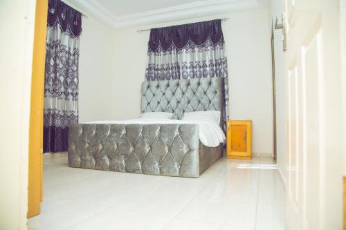 a bedroom with a large bed with a large window at SeneGambia Beach Apartments in Bijilo