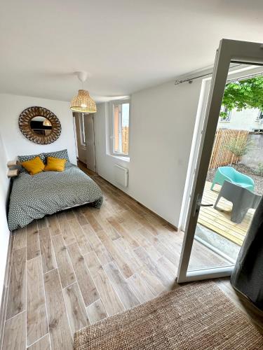 - un salon avec un lit et un miroir dans l'établissement Evasion dépaysante Canal du Midi* Jardin &Terrasse, à Castelnaudary