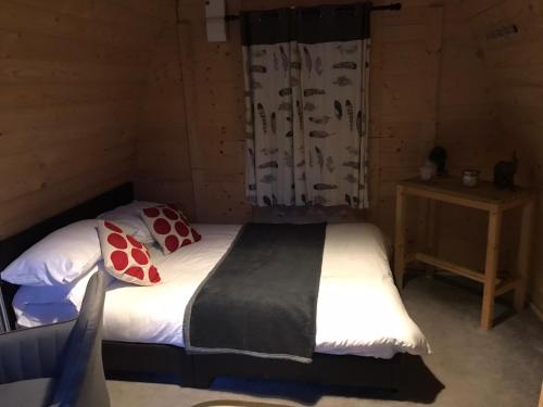 a bedroom with a bed in a wooden room at Camping Pods at Colliford Tavern in Bodmin