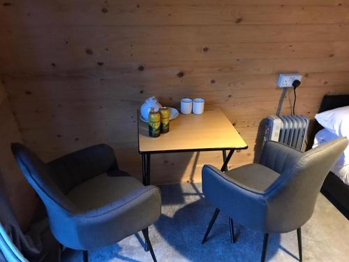 a room with a table and two chairs and a bed at Camping Pods at Colliford Tavern in Bodmin