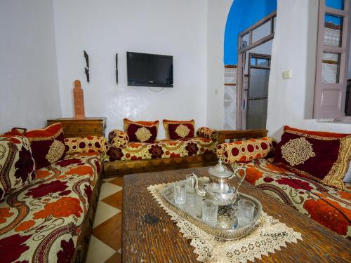 - un salon avec des canapés, une table et une télévision dans l'établissement Al janah 1, à Chefchaouen