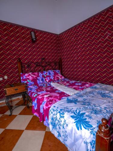- une chambre avec un lit et un mur rouge dans l'établissement Al janah 1, à Chefchaouen