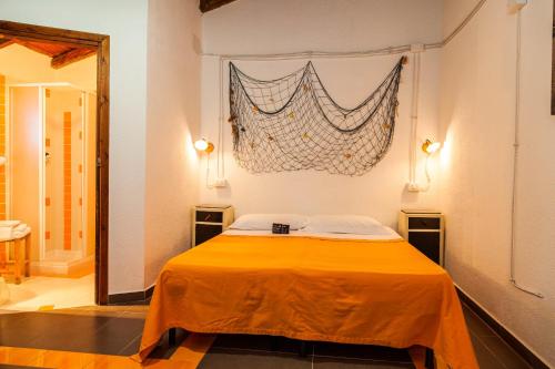 Un dormitorio con una cama con una sábana naranja. en The Old Farm Asfodeli - Adults Only, en Sanalvò