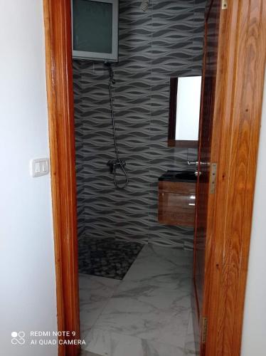 a bathroom with a television on a wall at Galia in Rafrāf