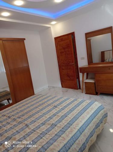 a bedroom with a bed and a dresser and a mirror at Galia in Rafrāf
