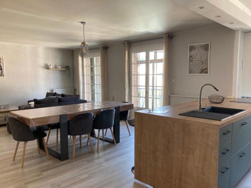 une cuisine avec un évier et une table avec des chaises dans l'établissement NATURE by Reine du Sud, proche des Grands Buffets, à Narbonne