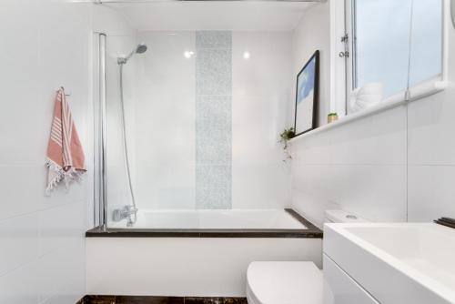 a white bathroom with a tub and a toilet at The Penthouse 3 Minutes To The Beach, Super Comfy Beds, Part of Burlington-Escapes in Brighton & Hove