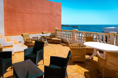 une terrasse avec des tables et des chaises et l'océan dans l'établissement Hostel Blue Lagoon, à La Mareta