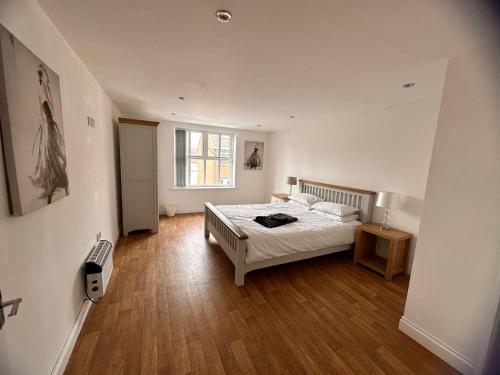 a bedroom with a bed and a wooden floor at Joe Kelly Buildings A in Withernsea