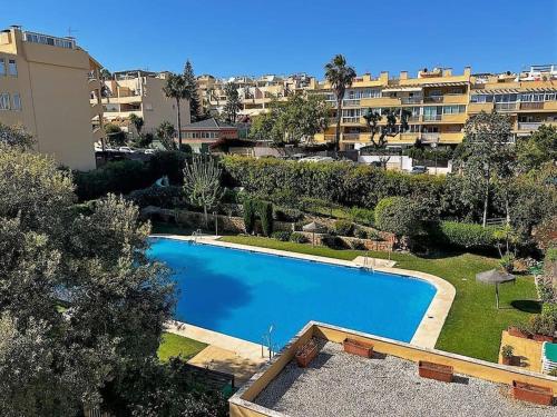 una gran piscina azul en un patio con edificios en Apartment close to Marbella, en Cabopino