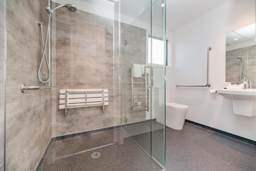 a bathroom with a glass shower and a sink at Starbright Townhouse in Twizel
