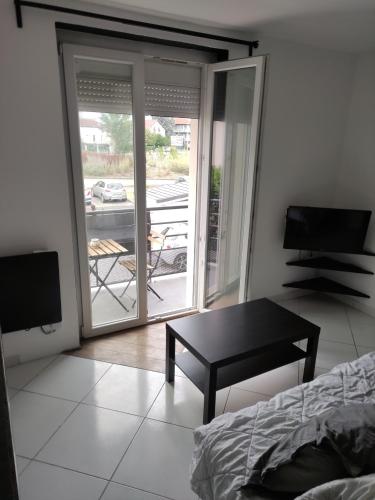 une chambre avec une table et une vue sur un patio dans l'établissement Studio bien situé avec un balcon, à Eybens