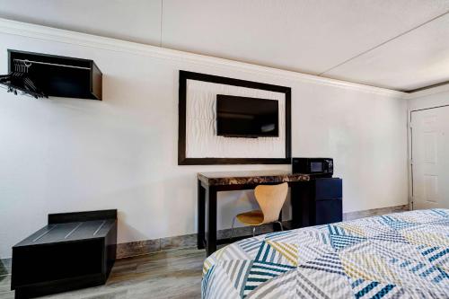 a bedroom with a bed and a tv on a wall at Motel 6 North Little Rock, AR-JFK Blvd in North Little Rock
