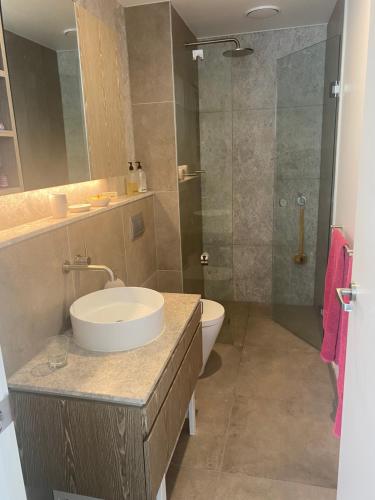 een badkamer met een wastafel, een toilet en een douche bij Spacious 2 bed apartment, great location in Melbourne