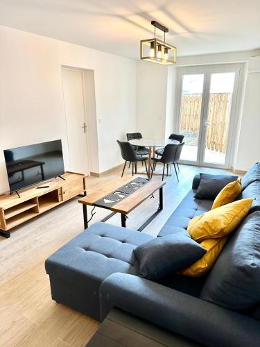 un salon avec un canapé bleu et une table dans l'établissement Evasion dépaysante Canal du Midi * Terrasse & SPA, à Castelnaudary