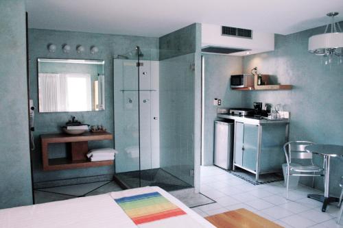 a kitchen with a glass shower and a kitchen with a table at Hotel Rio Malecon in Puerto Vallarta