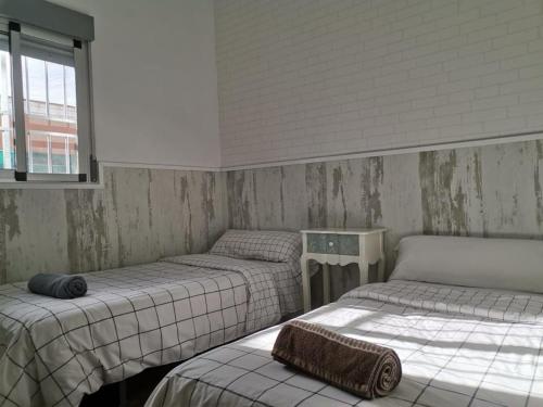 um quarto com duas camas e uma janela em La Caseta de Jose em Mareny Barraquetas