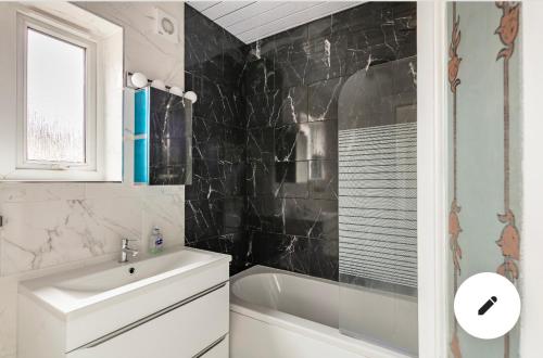 a bathroom with a sink and a bath tub and a sink at Cheerful 3 bedroom entire home - newly furnished in Stockport