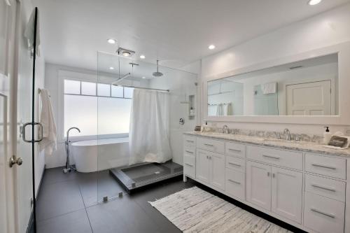 a bathroom with two sinks and a tub and a mirror at Luxury Ocean Views & Steps To The Sand - Tower 36 Lower Condo Unit in Carlsbad