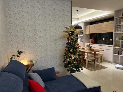 a living room with a blue couch and a christmas tree at 三木三白包棟民宿 in Puli