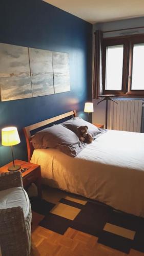 un chien assis sur un lit dans une chambre dans l'établissement Appartement tout équipé pour 4per parking privatif, à Suresnes