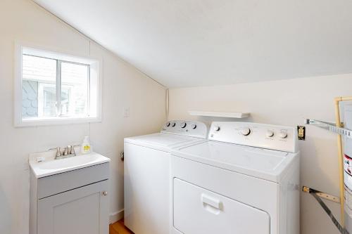 a white laundry room with a washer and a sink at Beach Bliss in Long Beach