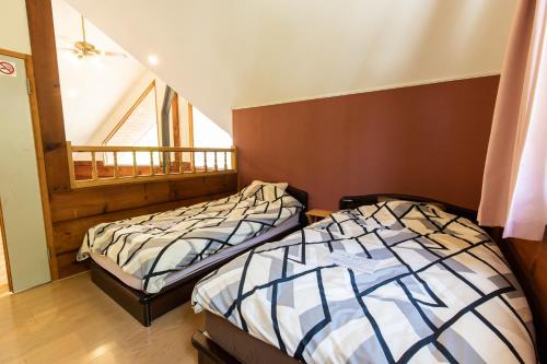two twin beds in a room with a window at ログハウスkizuki in Tsuru 