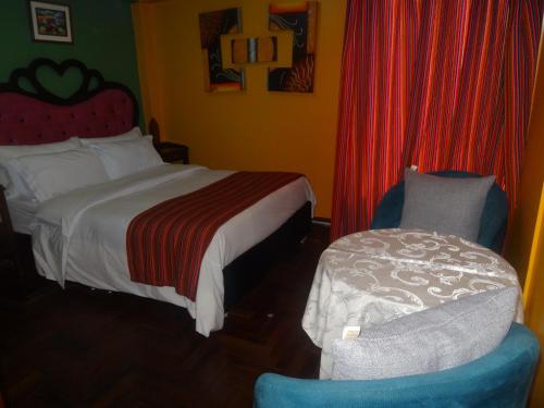 a hotel room with a bed and a chair at Hostal Casa Del Inka in Cusco