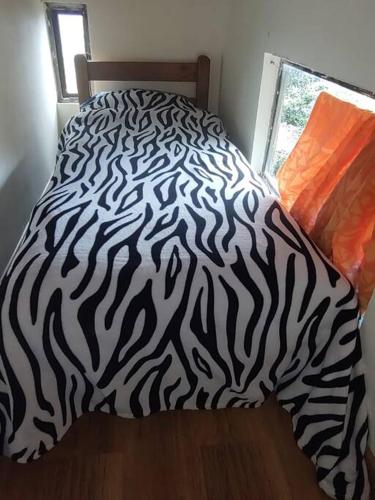 a bed with a black and white zebra blanket at La casa de chocolate 1 in Bogotá