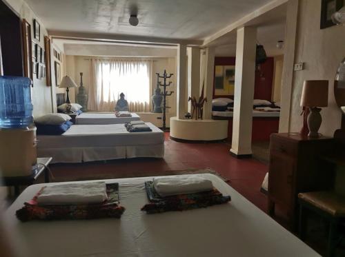 Großes Zimmer mit 2 Betten und einem Tisch in der Unterkunft CASA CONCHITA BED & BREAKFAST in Taal