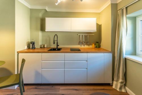 a kitchen with white cabinets and a sink at Villa Wickenburg in Salzburg