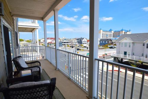 a balcony with two chairs and a view of a street at Sea Bright 205 condo in Ocean City